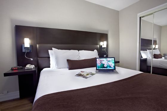 Bedroom with laptop on bed at Town Inn Suites Toronto