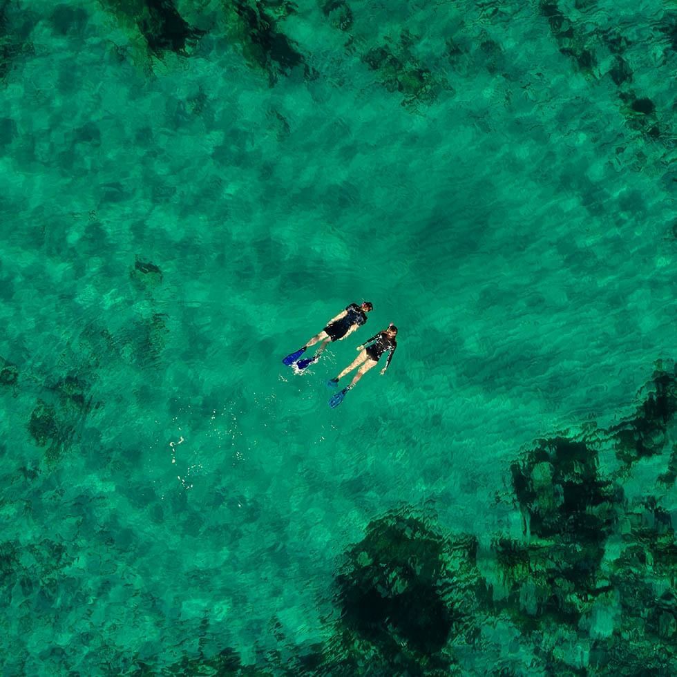 High-angle view of 2 divers swimming near Falkensteiner Hotels