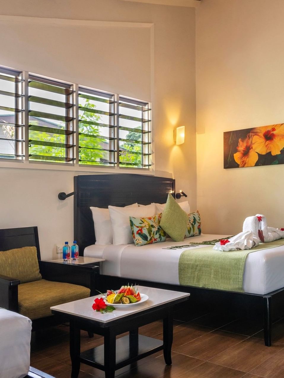 Studio Villa with two beds, a chair, and a table at Tokatoka Resort - Fiji International Airport in Nadi.