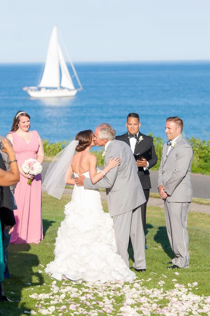 Wedding ceremony held outdoors with a sea view at Ogunquit Collection