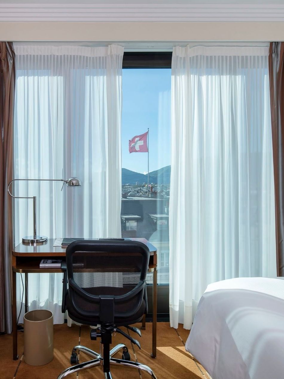 Classic Single Room featuring a wooden desk by a window and a large bed at Warwick Geneva