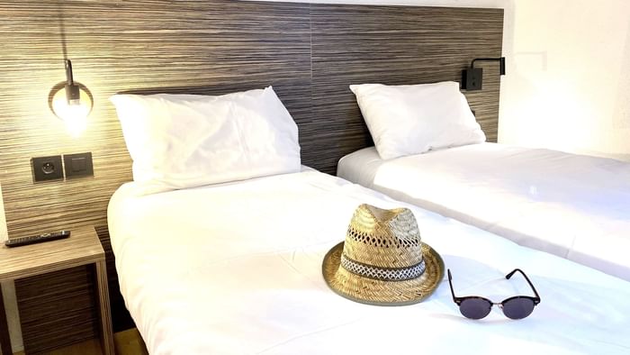 Hat & shade on a bed in Angers South at The Originals Hotels