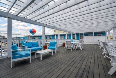 Outdoor deck with furniture and cushions, featuring a colorful water tower in the background at Madison Beach Motel