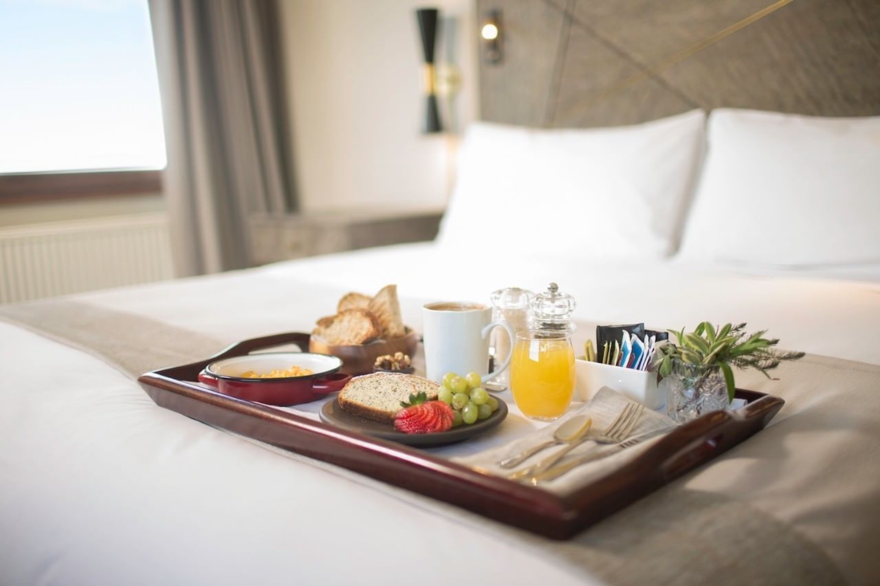 Breakfast plates on a bed at Hotel Cabo de Hornos