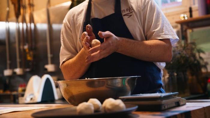 Chef kneading dough in an industrial kitchen. 