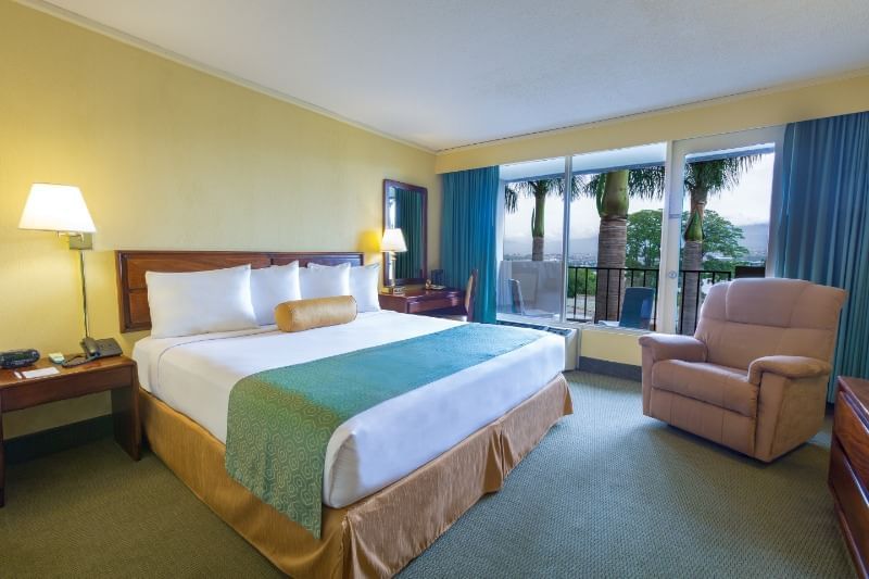 Acogedora cama, sofá & lámparas de noche en habitación King Standard con vista a la piscina y balcón en el Hotel Irazu