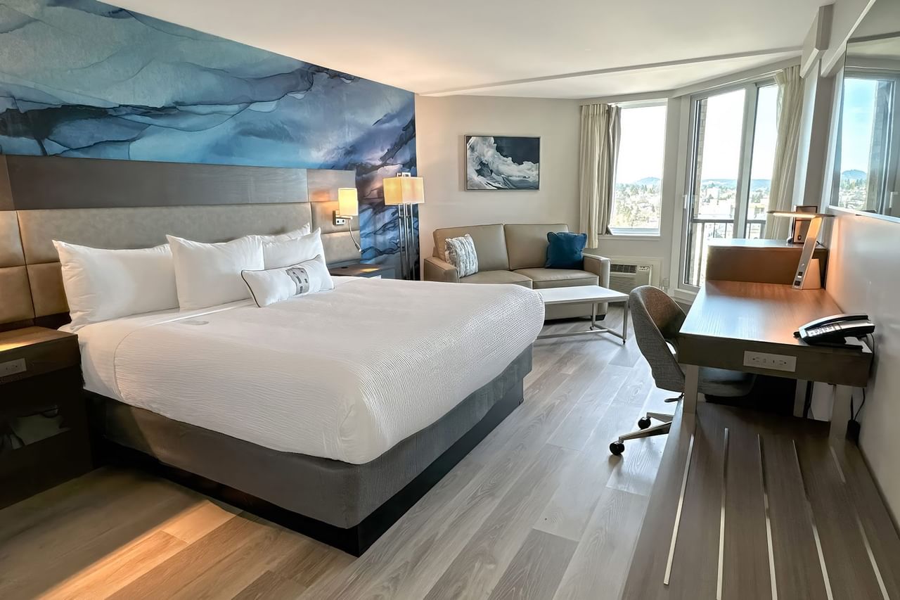 Hotel guestroom with king bed and a blue wall mural
