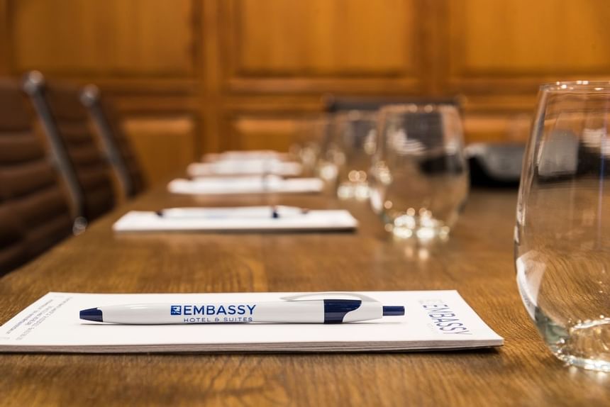 boardroom table with embassy notepads and pens for every chair