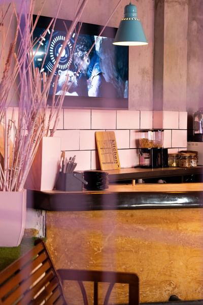 Kitchen counter with a large screen showing a movie and dried plants at Panama Hotel