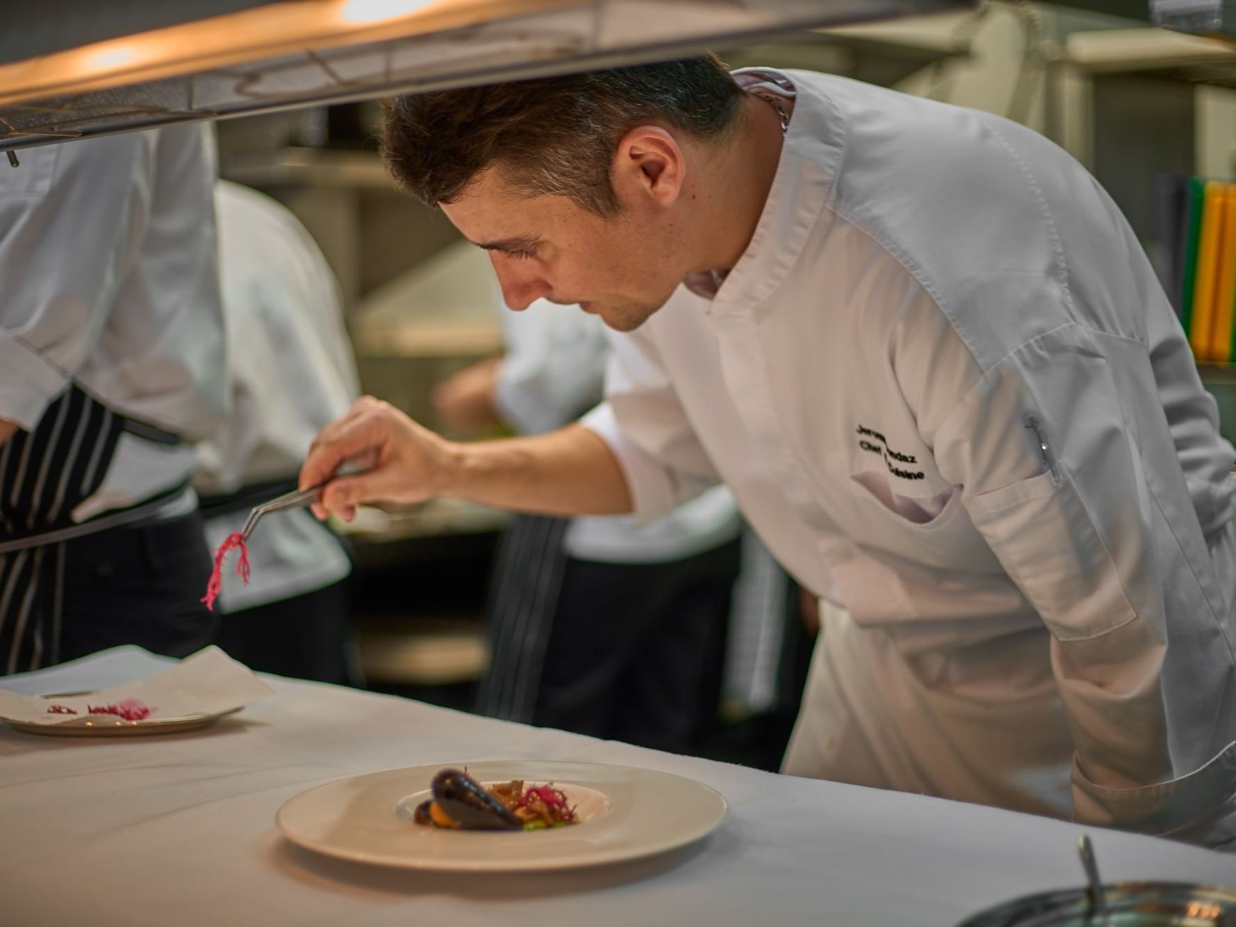 Chef garnishing a dish in the kitchen at Chatrium Hotels