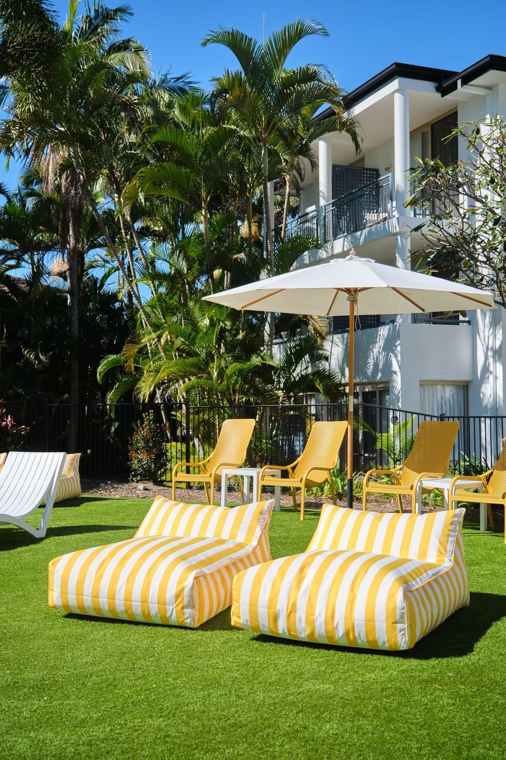 Yellow bean bags and sunbeds poolside for relaxing at Mercure Gold Coast Resort