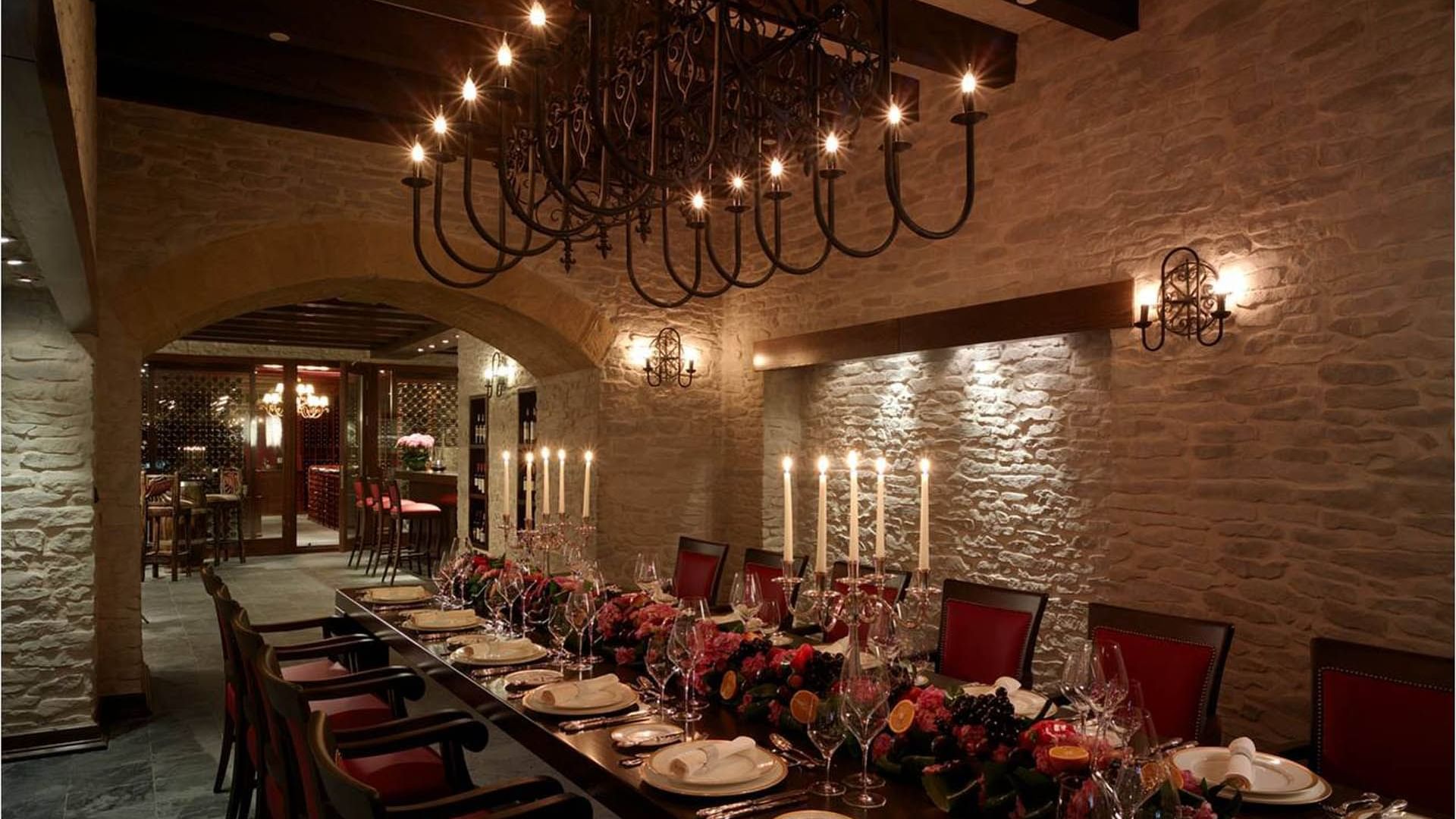 Long dining table arranged with plates and cutlery items in Wine Cellar at Titanic Mardan Palace