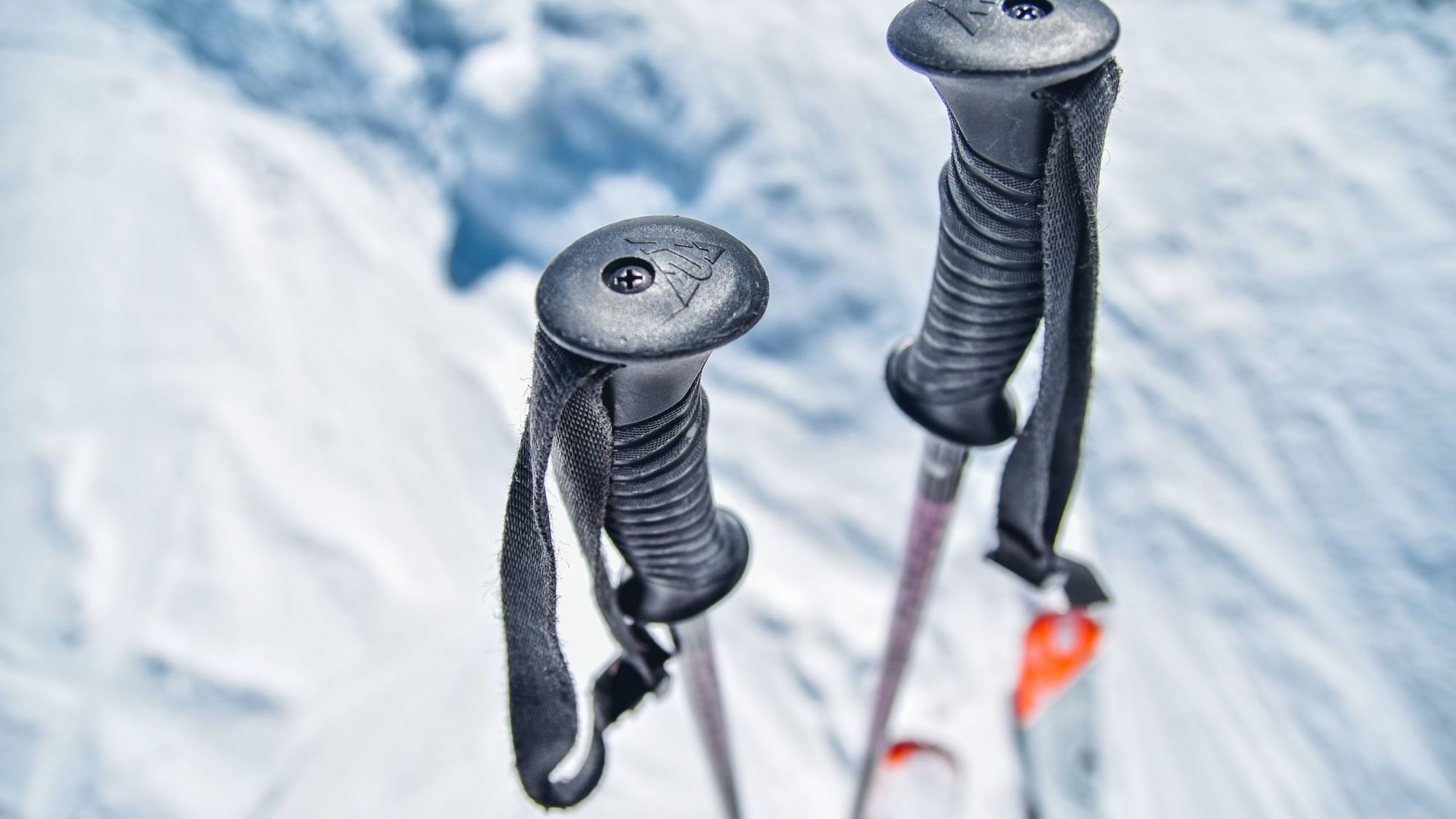 Closeup of ski poles on a snowy mountain near Originals Hotels