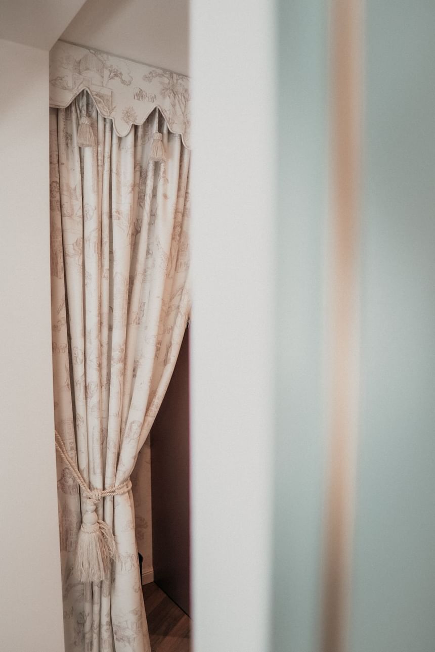 Bright patterned curtain tied together with a cord in the hotel in Vienna