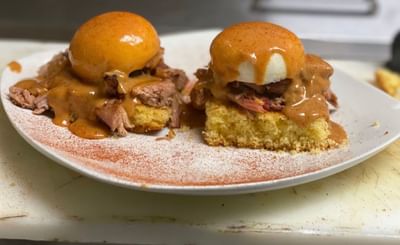 Two eggs benedicts with meat & sauce served in The Boca Beach House near Ocean Lodge Boca Raton