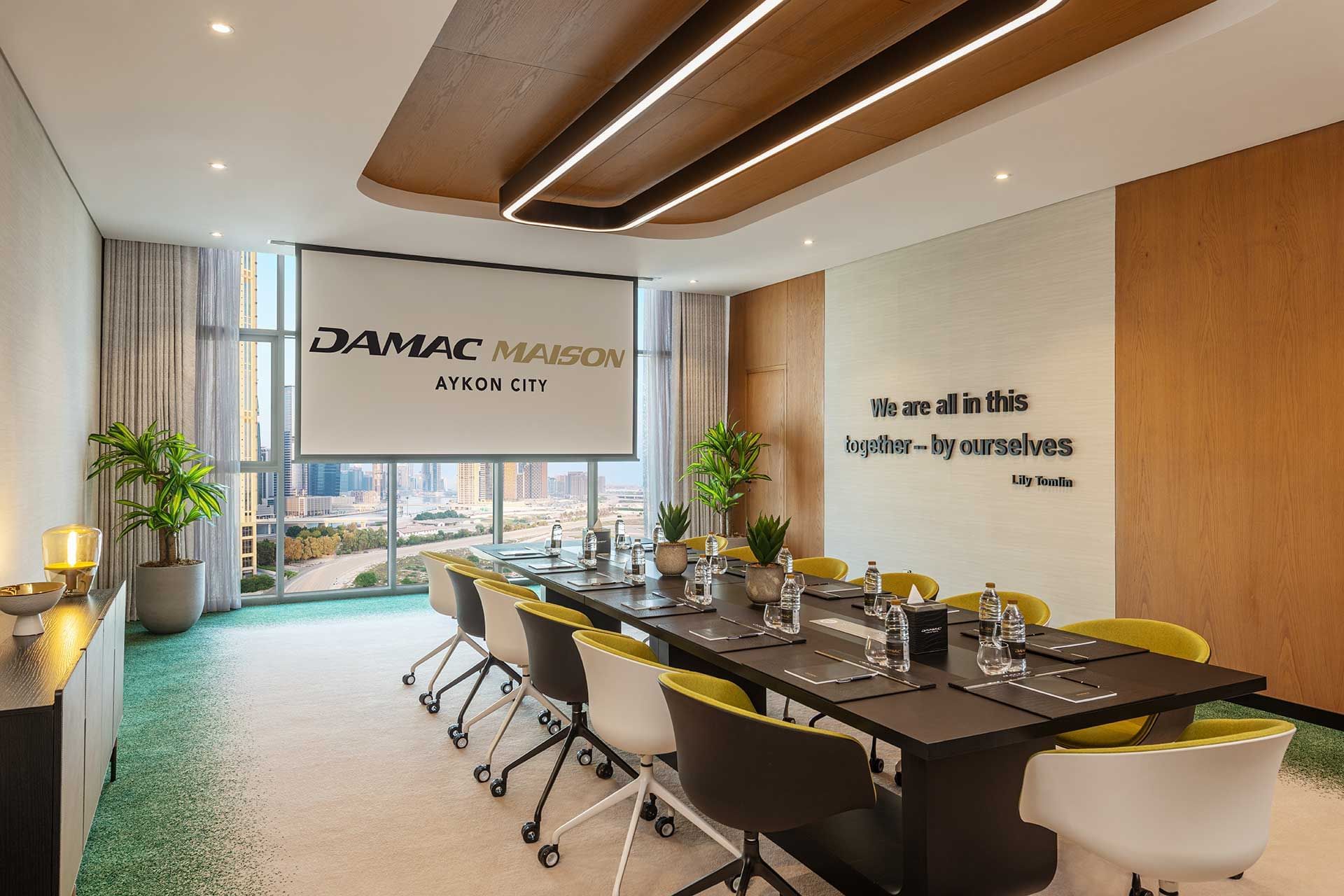 Modern conference room with a large table, chairs, and city view at DAMAC Maison Aykon City