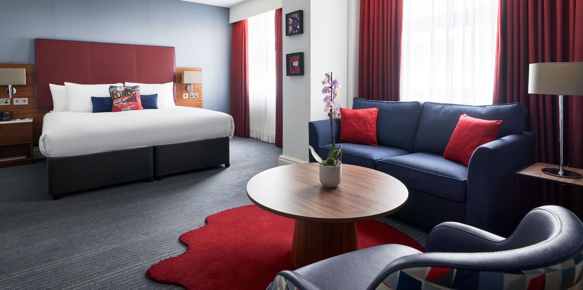 A comfy bed & sofas in Studio Suite at The Cumberland Hotel