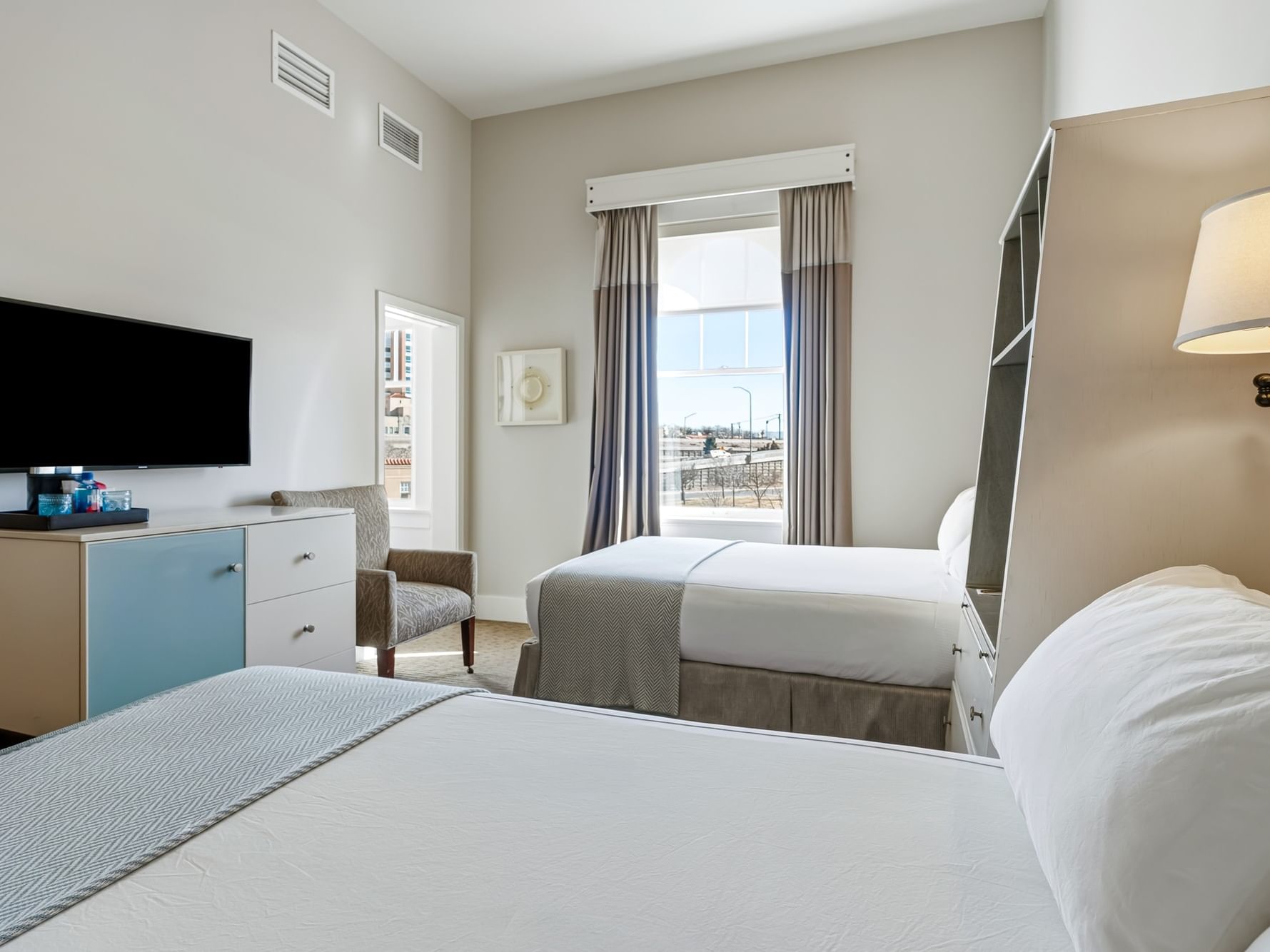 Two beds with modern decor and a window in a Traditional Double room at Hotel Parq Central in Albuquerque.