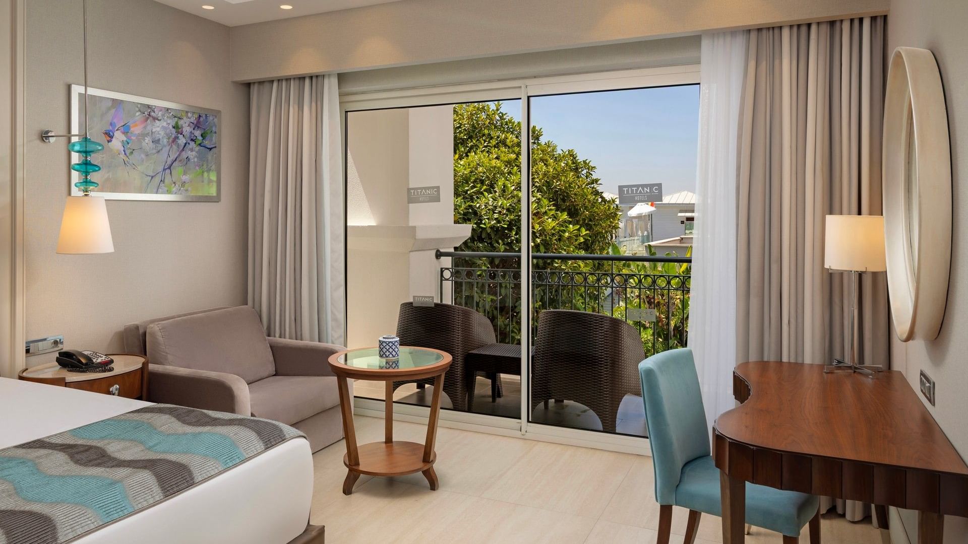 Modern suite with balcony seating, contemporary furnishings, and garden views at Titanic Deluxe Golf Belek, Antalya.