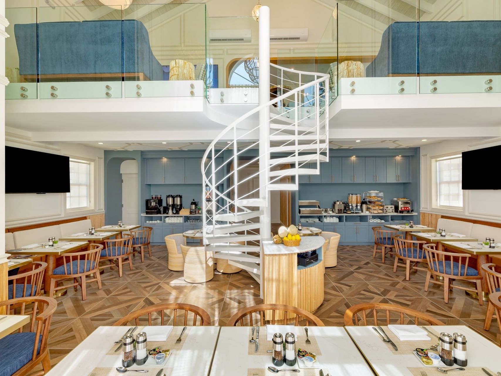 Bright, modern dining area featuring wooden tables at Beachfront Club room in Windsong Resort On The Reef