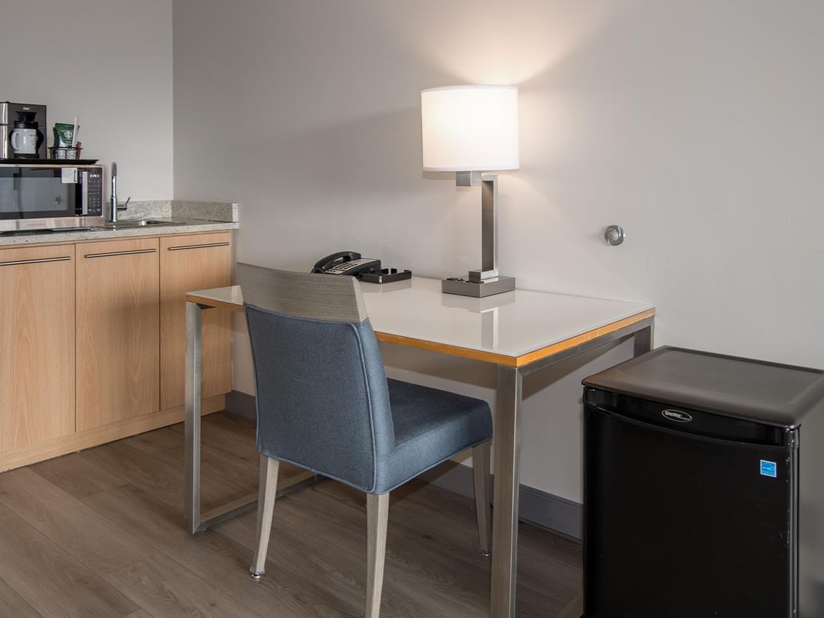 Desk with lamp and chair in a hotel room.