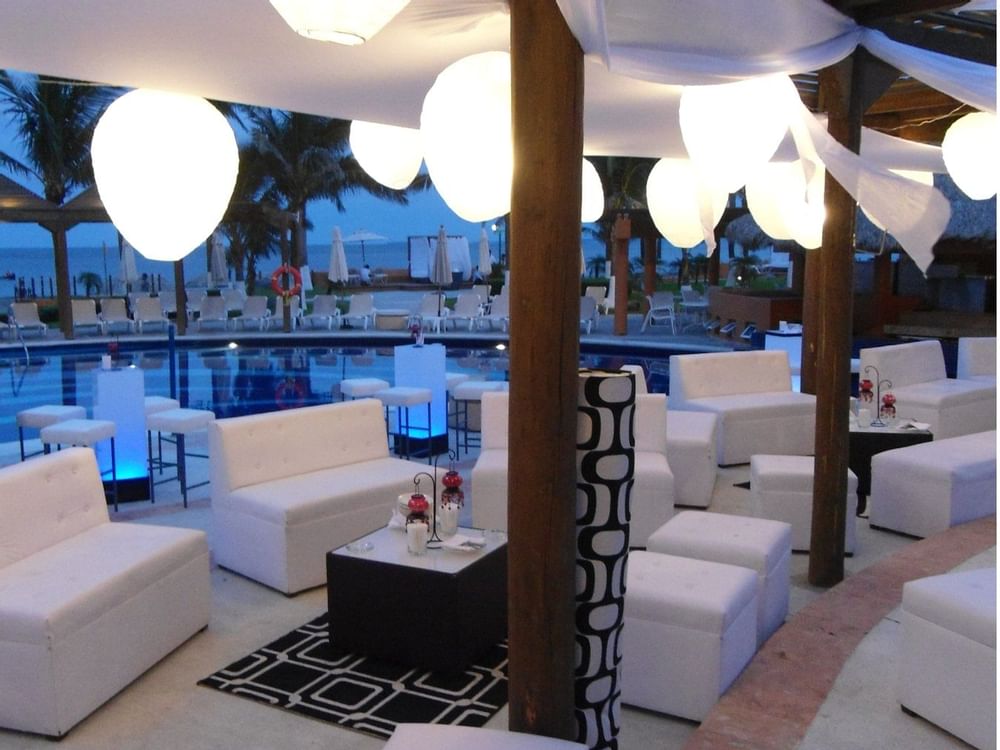 Outdoor lounge by poolside at Grand Fiesta Americana