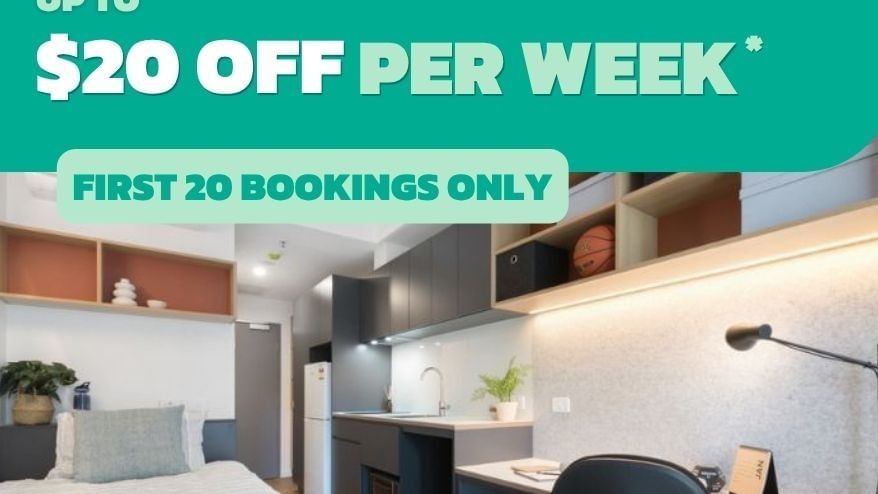 Modern studio apartment with kitchenette, desk, and bed featuring a promotional offer for UniLodge Melbourne Central.