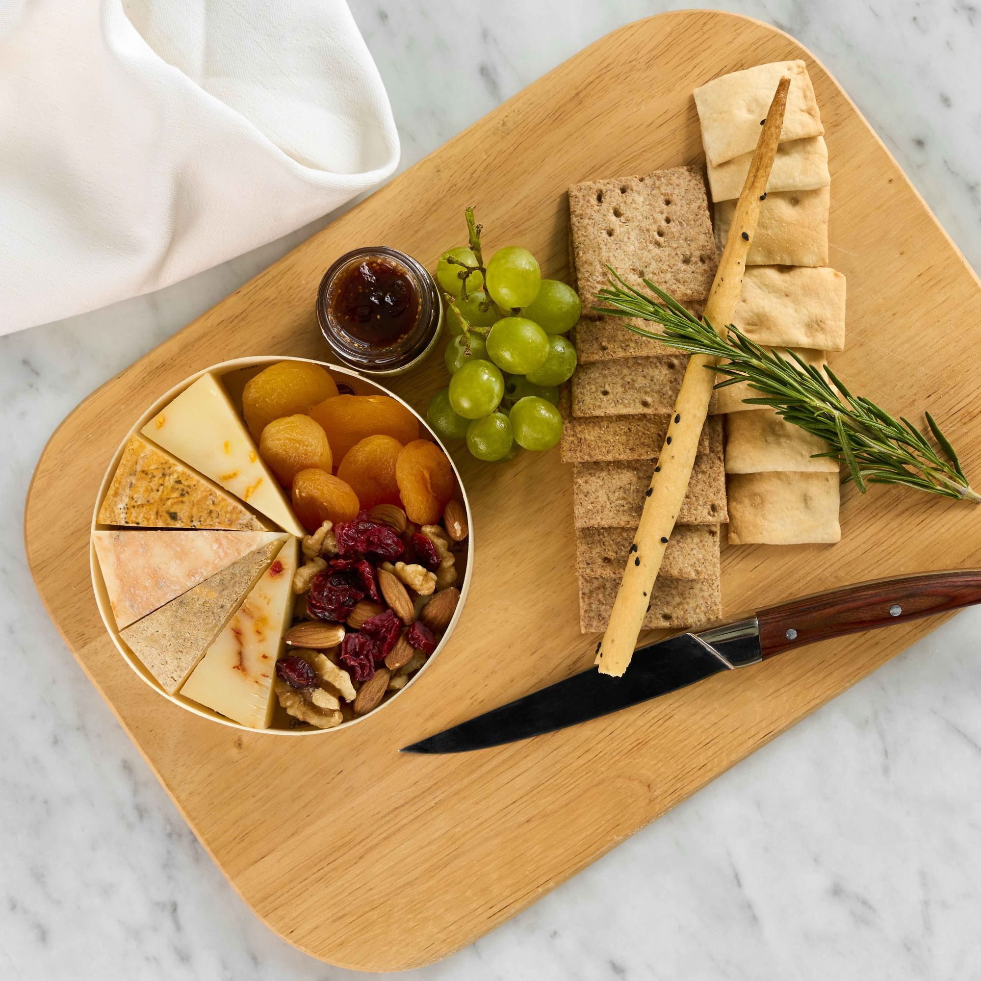 Cheese, grapes, and focaccia served on a charcuterie board in Paparazzi Tuscan at Paramount Hotel Midtown
