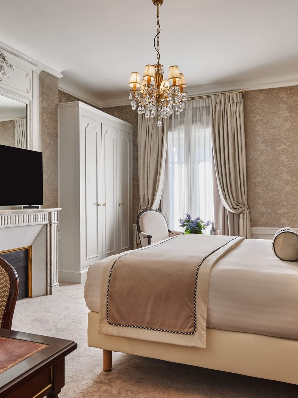 TV facing bed with couch and wood cupboard near window in Executive Room – Rue de la Paix View at Hotel Westminster Paris
