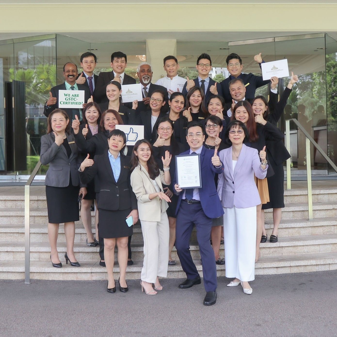 The dedicated team at Goodwood Park Hotel celebrating their Great Place to Work certification on the hotel steps