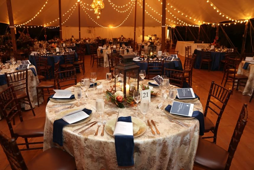 Banquet tables set up with glassware, cutlery & napkins in a wedding venue at The Clifton