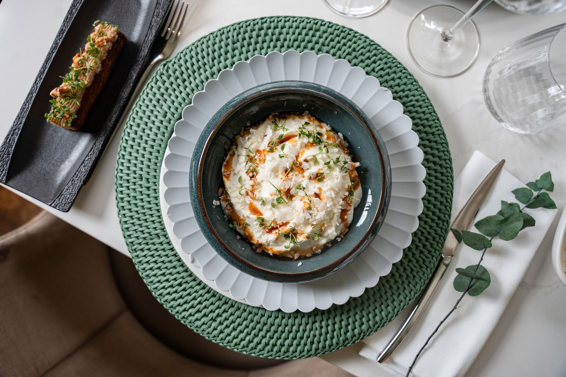 Plated dish with garnish and side dish on a placemat served in Le Céladon at Hotel Westminster Paris