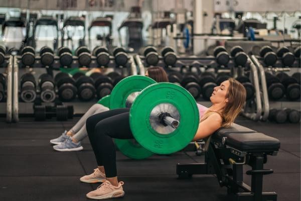 woman performing a barbell hip thrust