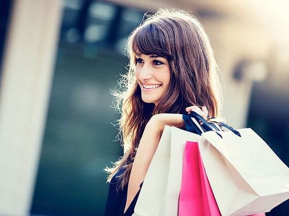A lady holding multiple shopping bags at Clique Hotels