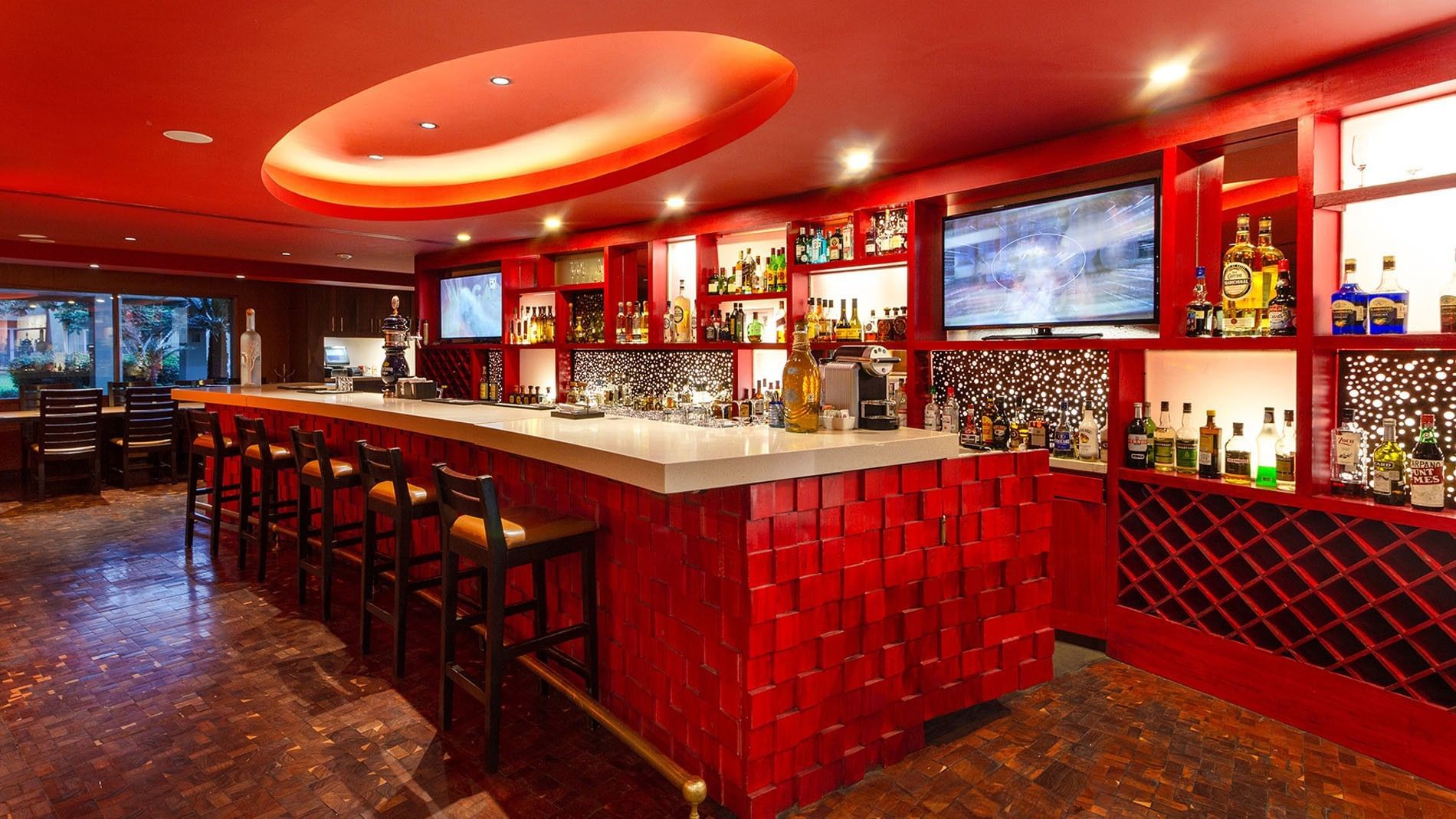 Vibrant María Bonita bar featuring an illuminated counter, wine racks, and plush seating at Camino Real Guadalajara