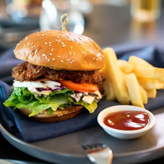 Burger served with french fries Shallows Bar at Pullman Magenta Shores