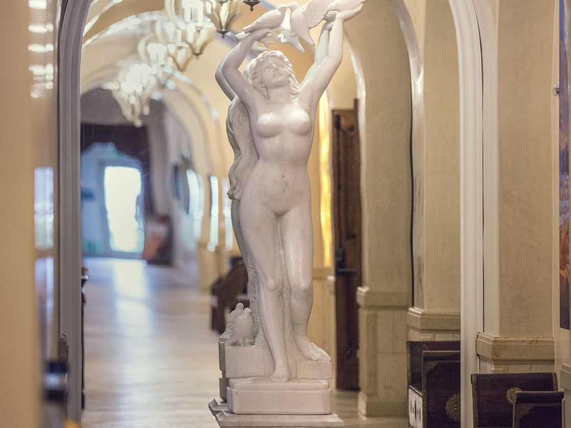 Statue of woman with birds at end of hallway