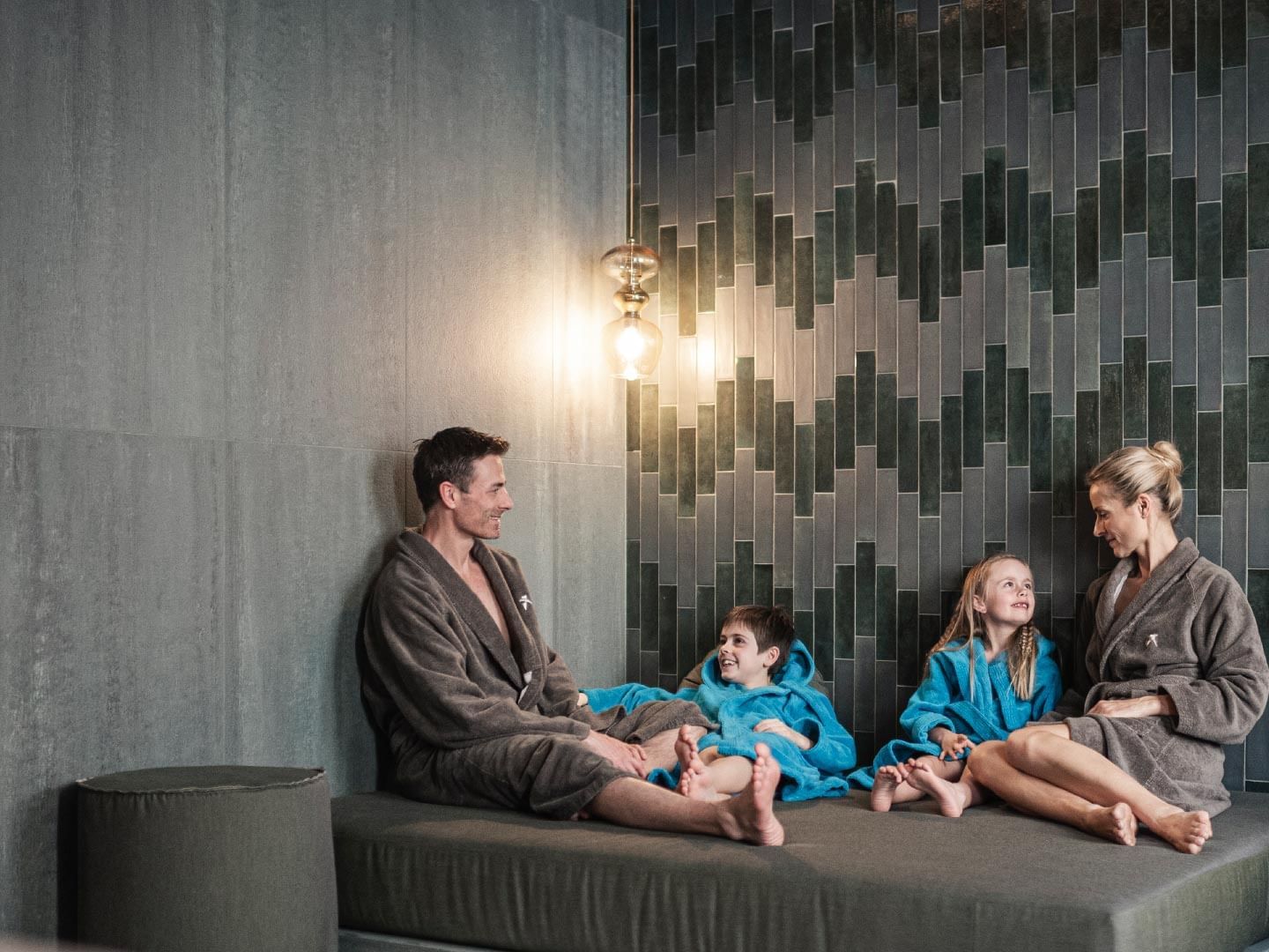 A family in bathrobes lounging in a spa at Falkensteiner Hotels