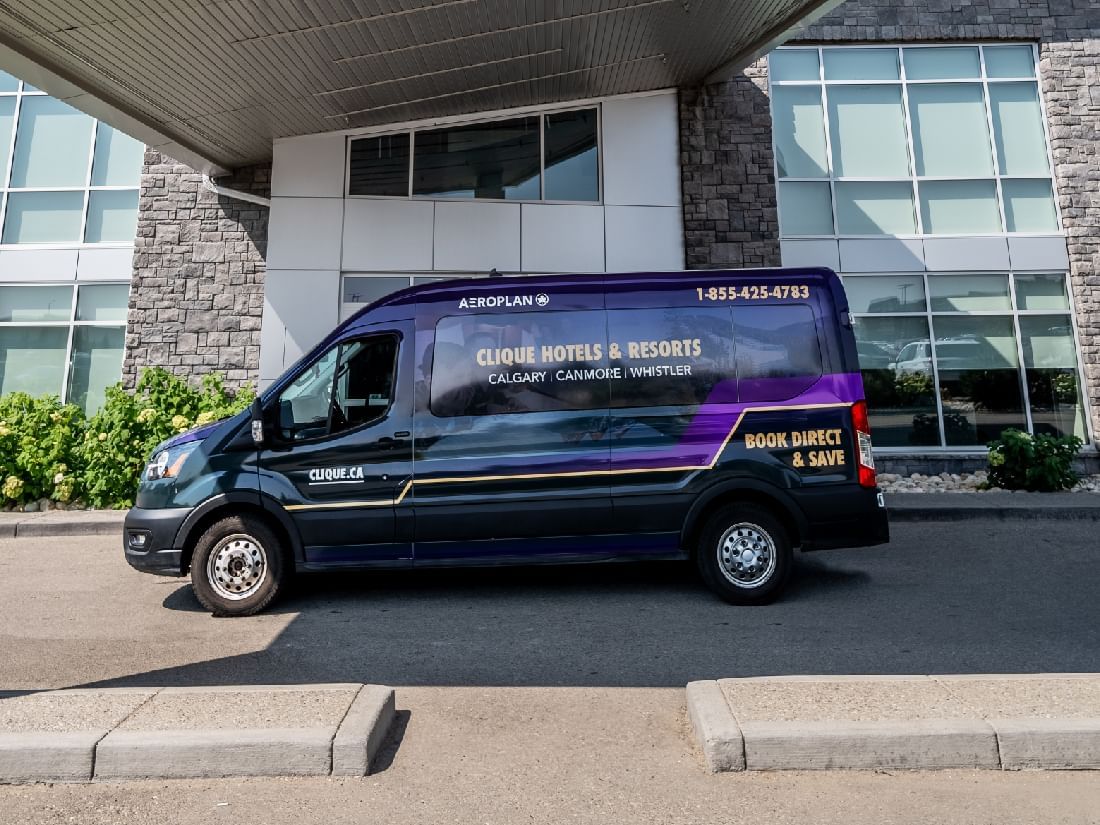 An Airport Shuttle parked in front of Hotel Clique Calgary Airport