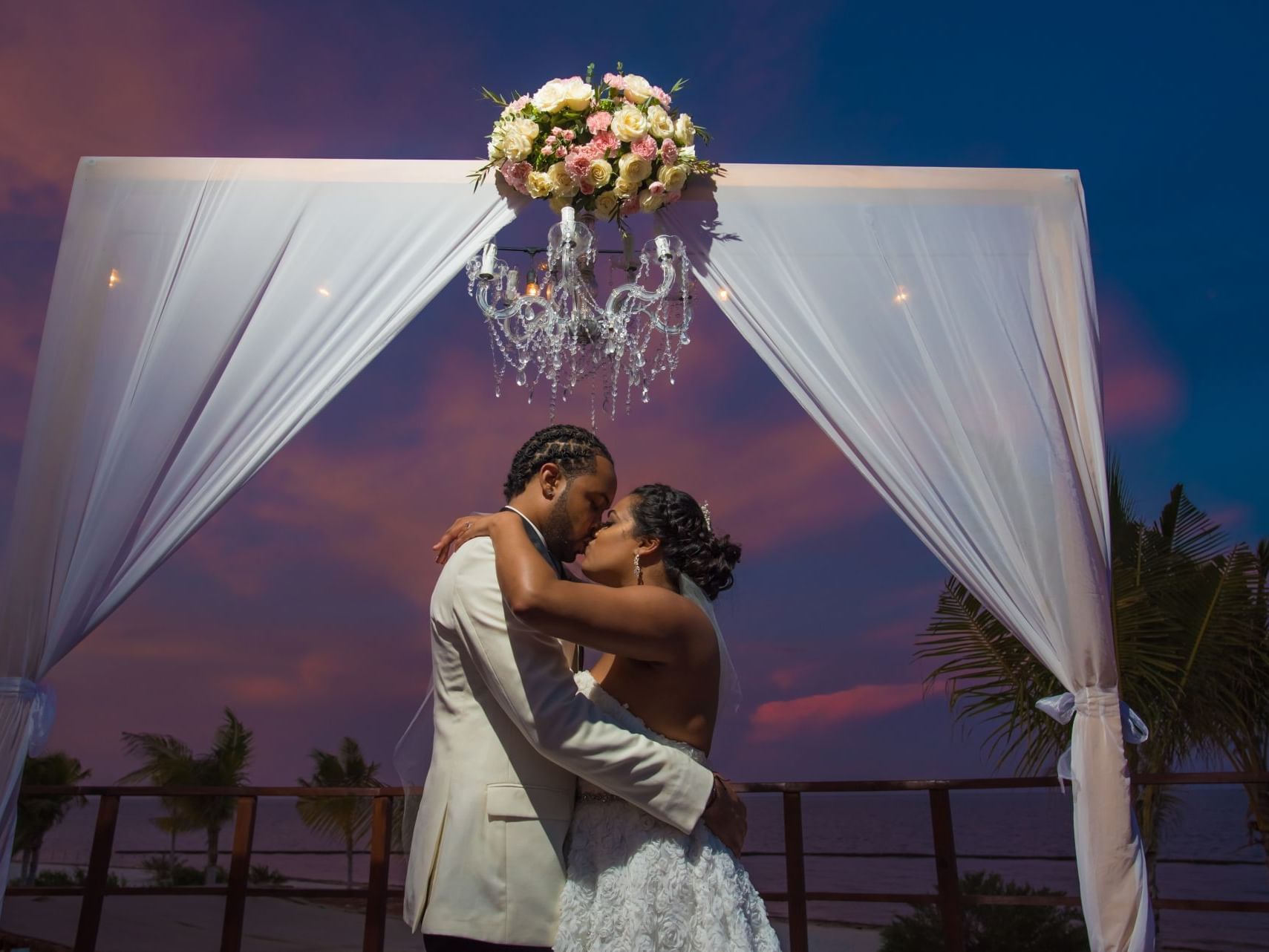 Wedded couple kissing on the aisle at Haven Riviera Cancun