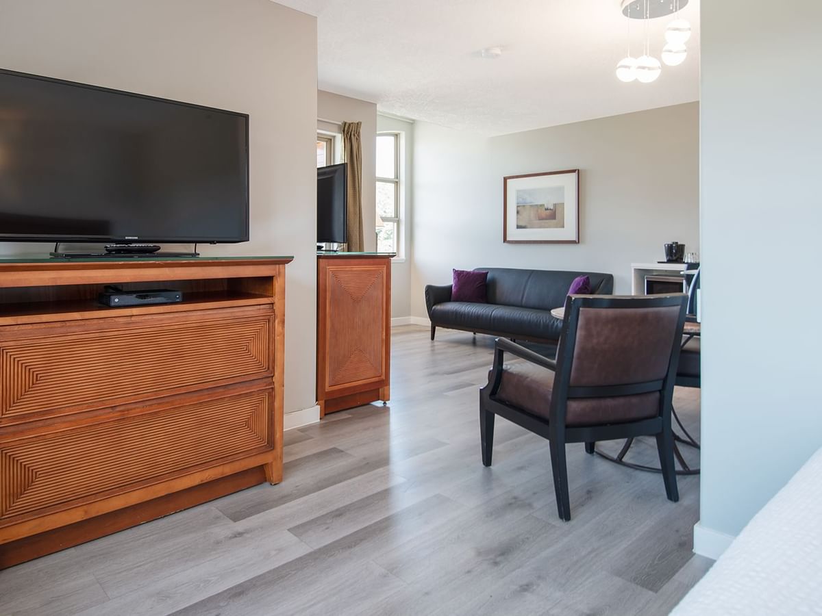 Hotel suite with couch, flat screen TV, table and chairs
