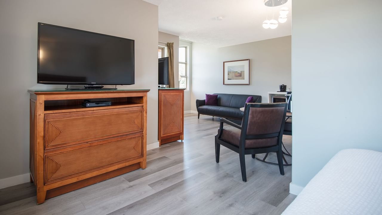 Hotel suite with couch, flat screen TV, table and chairs