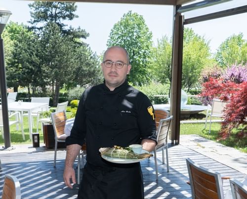 A Chef Holding a dish at Ana Hotels in Romania
