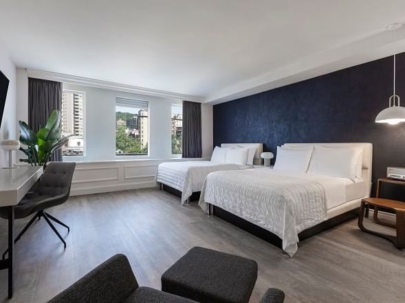 Deux lits doubles de luxe avec vue sur la ville au SENS Hotel