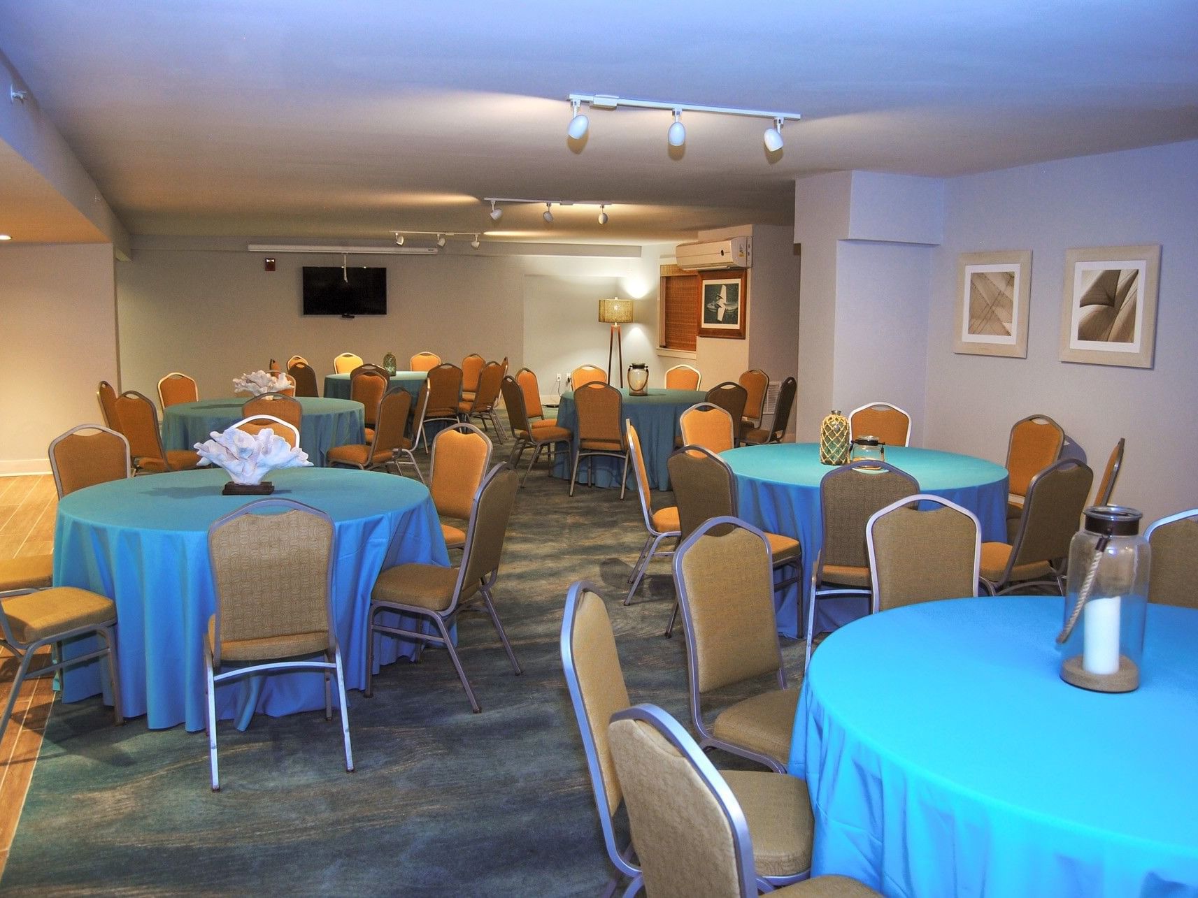 Large meeting room at Margaritaville Resort Biloxi featuring round tables with bright blue linens and chairs