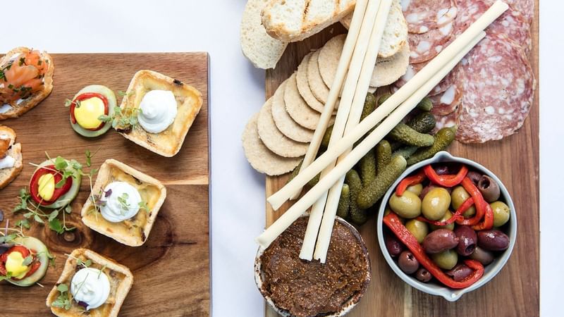 Overhead view of a canape board with meats, olives, crackers, and pate served in The Croft House at The Sebel Brisbane