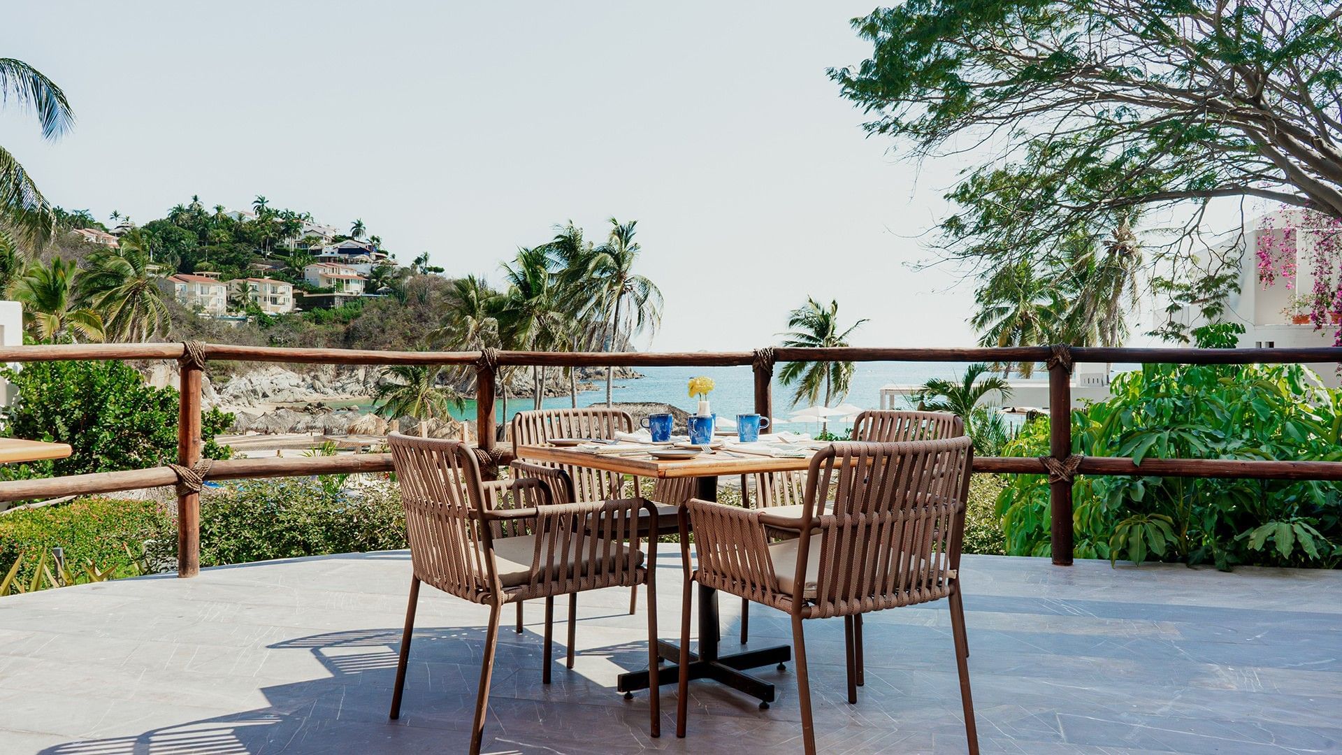 Outdoor terrace dining area with greenery and ocean views in Chez Binni at Camino Real Zaashila Huatulco