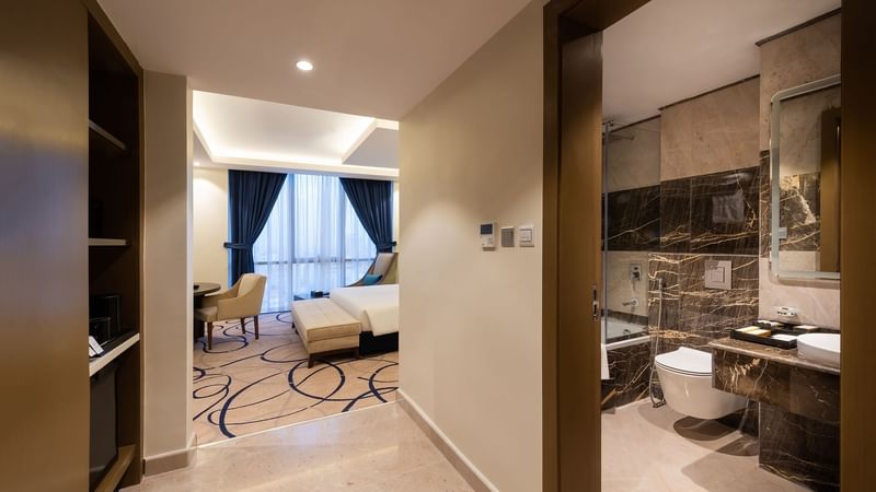 Bedroom area with bathroom in Standard Room at Warwick Riyadh