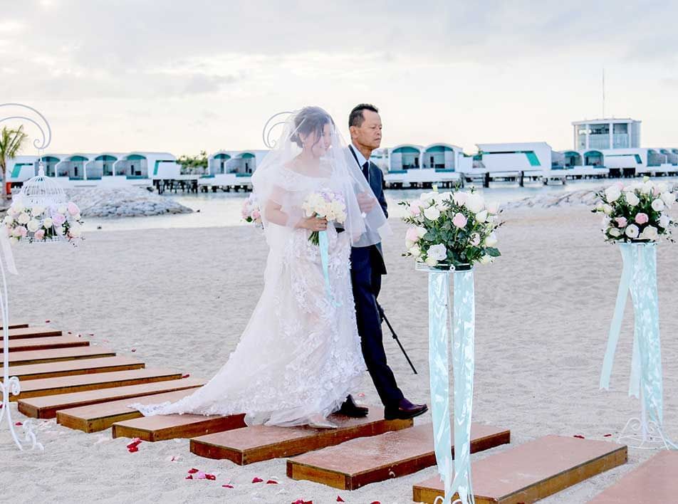 bride and groom walking down the aisle in a garden wedding - Lexis MY