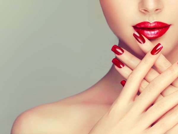 lower half of woman's face with red lipstick and her fingers wit